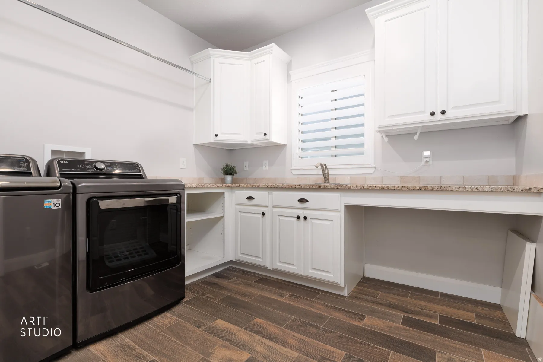 Laundry room with wood finish floors, washer and dryer, and cabinet space
