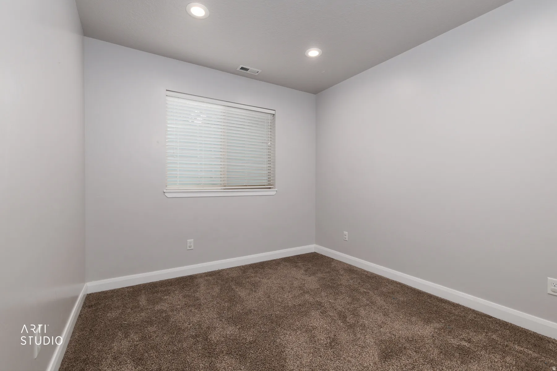 Spare room featuring baseboards and dark colored carpet