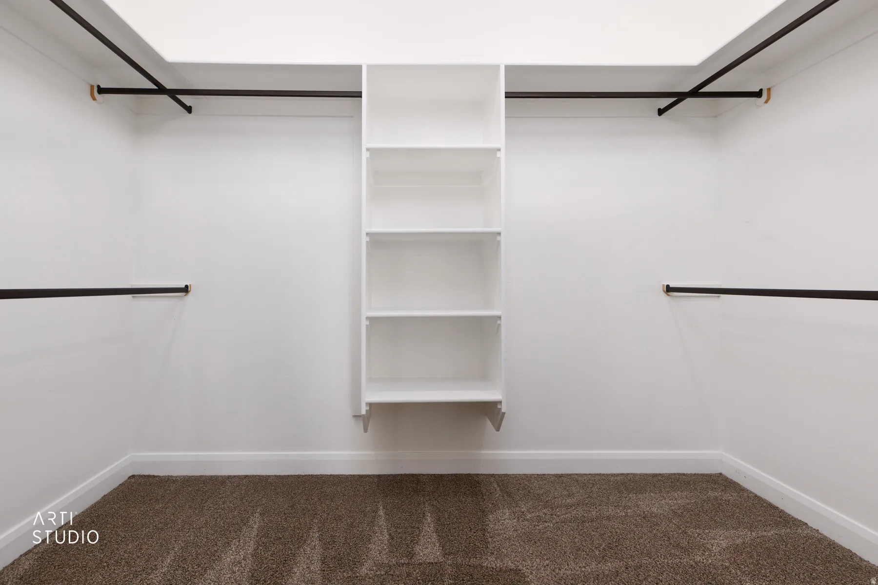 Walk in closet featuring dark carpet