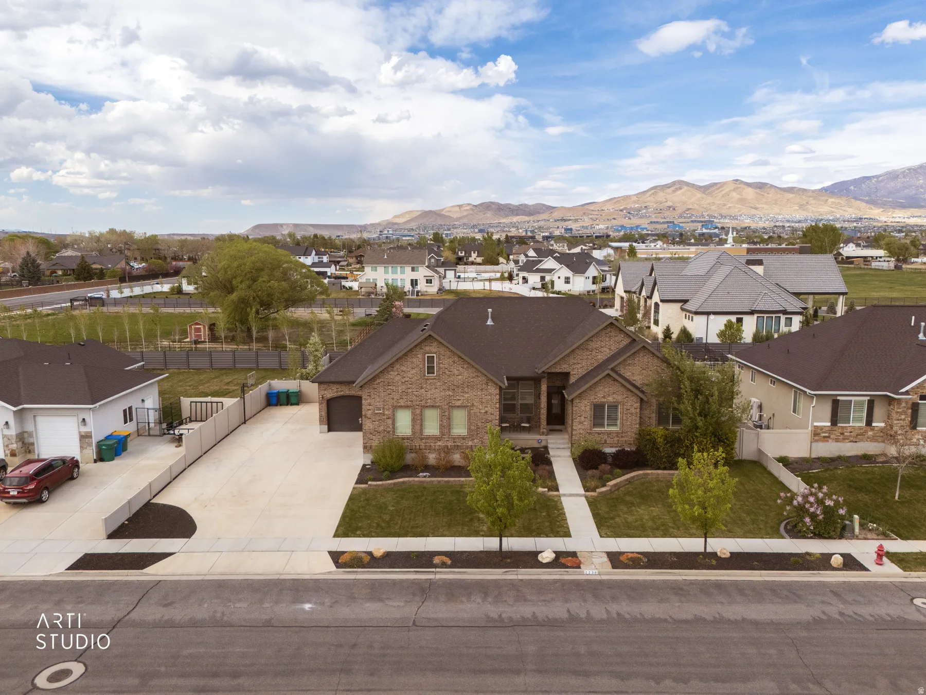 View of front of house featuring a residential view, a mountain view, brick siding, and driveway