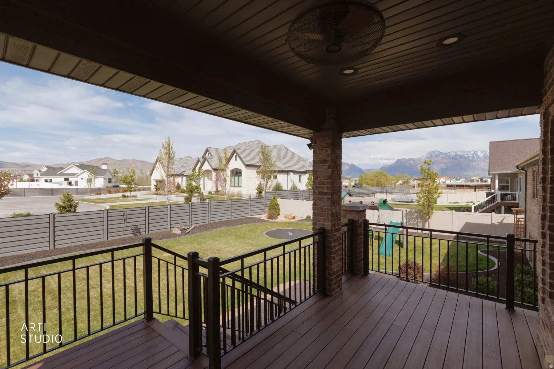 Wooden terrace featuring a residential view, a mountain view, and a fenced backyard
