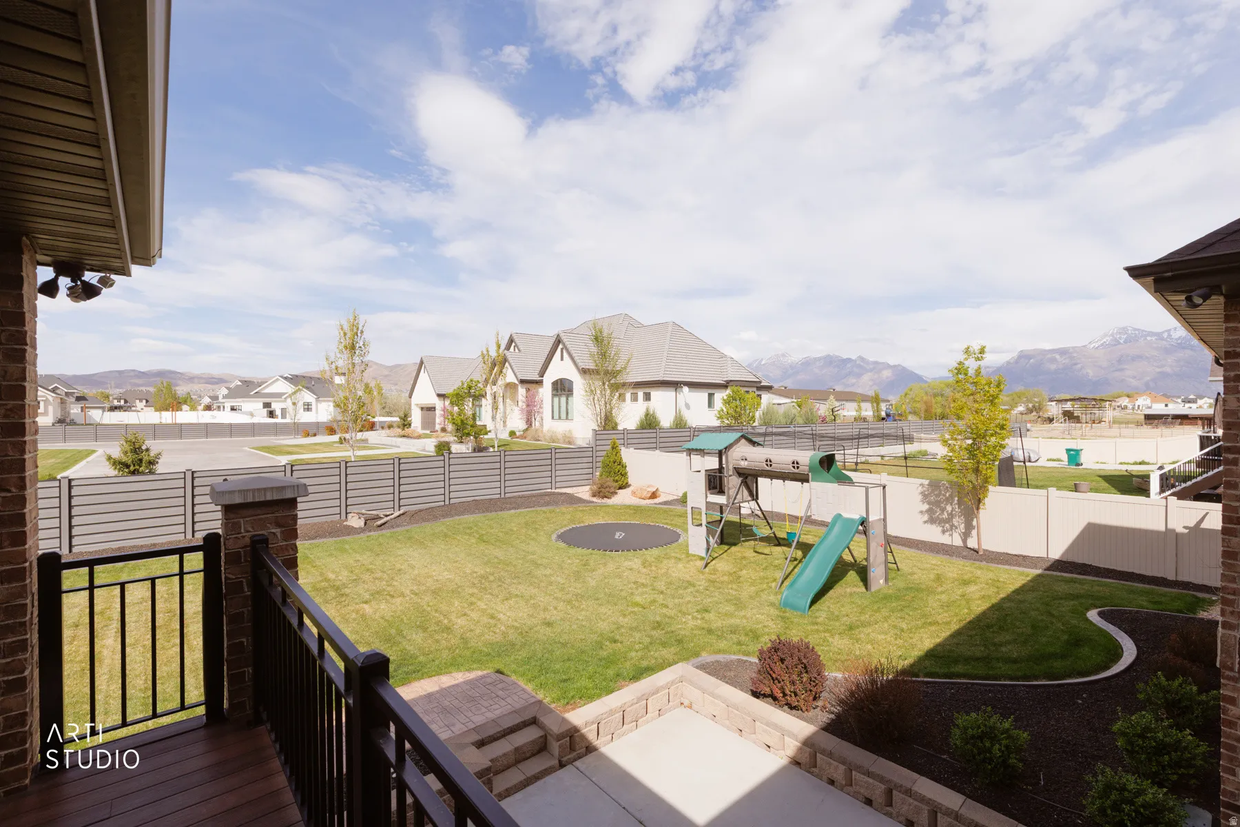 Fenced backyard with a residential view, a playground, a patio, and a mountain view