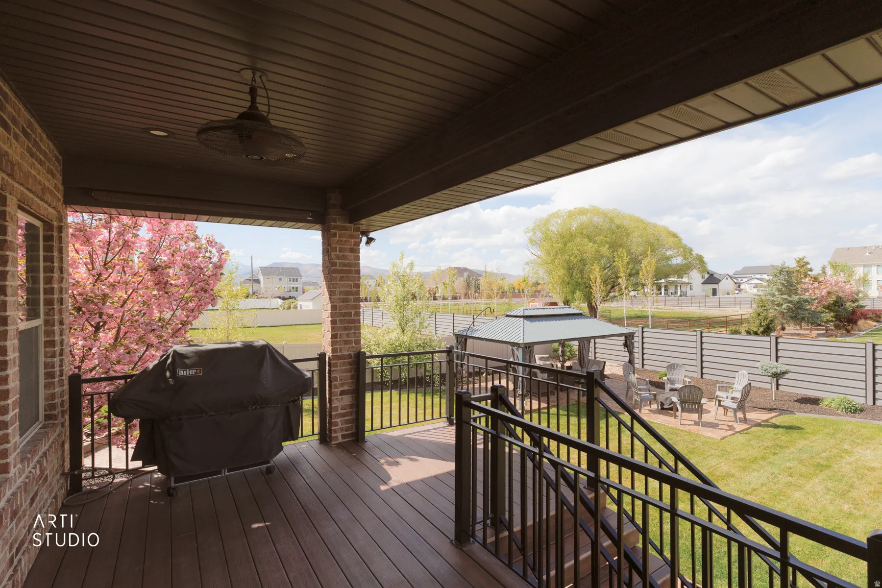 Deck featuring a gazebo, area for grilling, ceiling fan, a patio, and a residential view