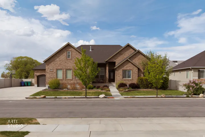 View of front facade with brick siding, an attached garage, concrete driveway, and roof with shingles