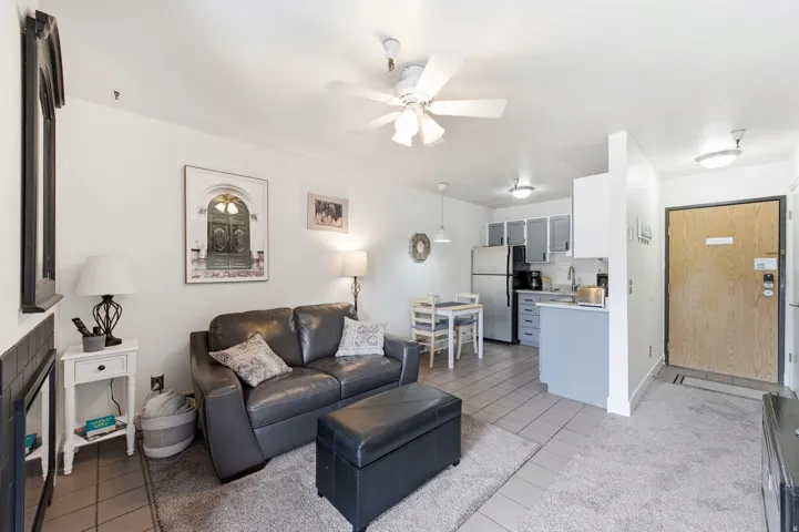 Living room with light tile patterned floors and ceiling fan