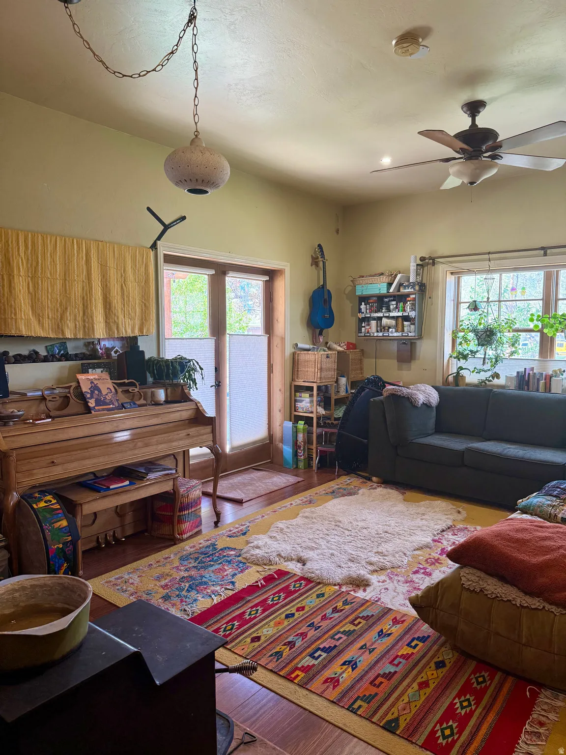 Living room featuring wood finished floors, ceiling fan, and french doors