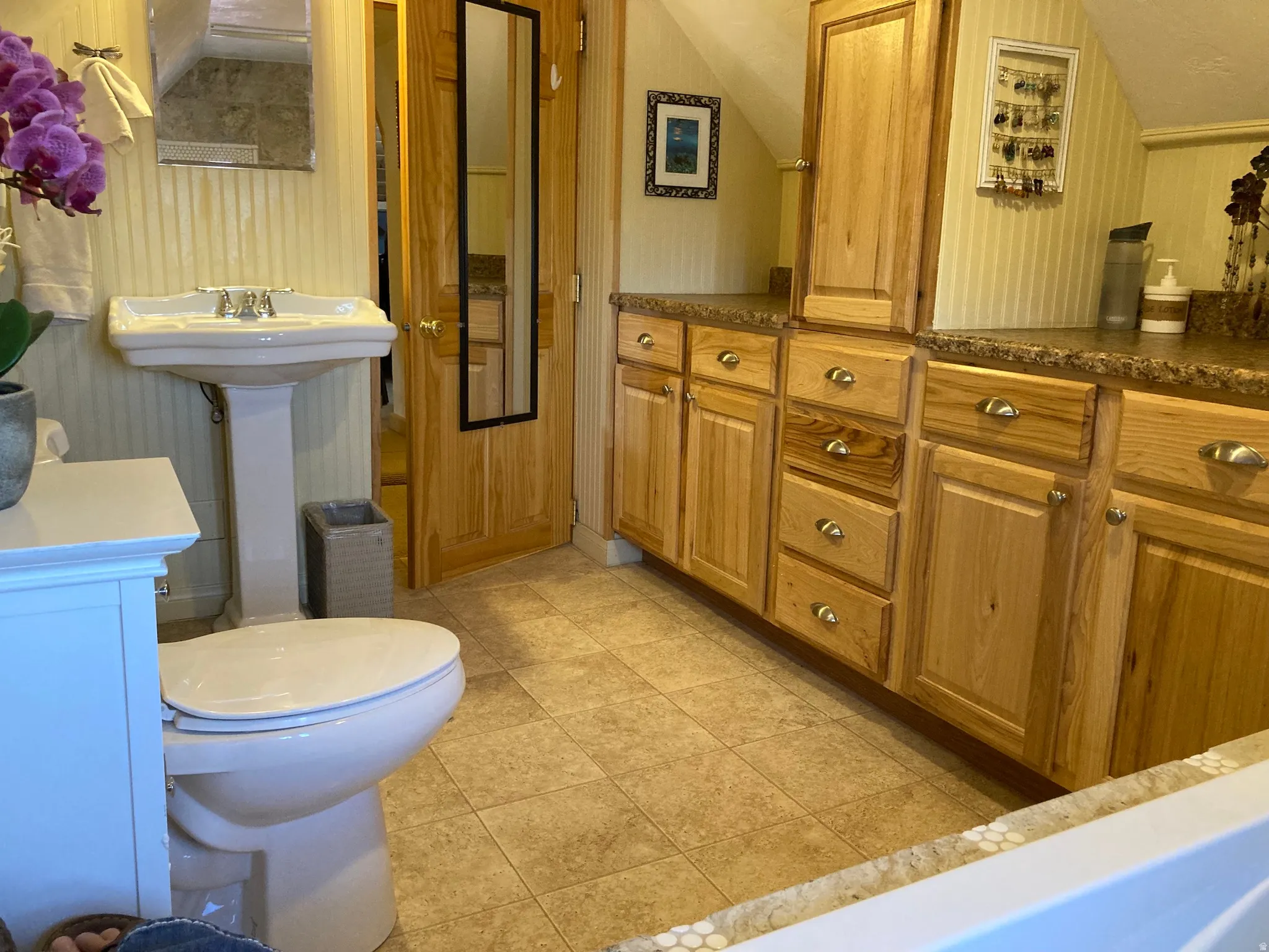 Bathroom with vaulted ceiling and light tile patterned floors