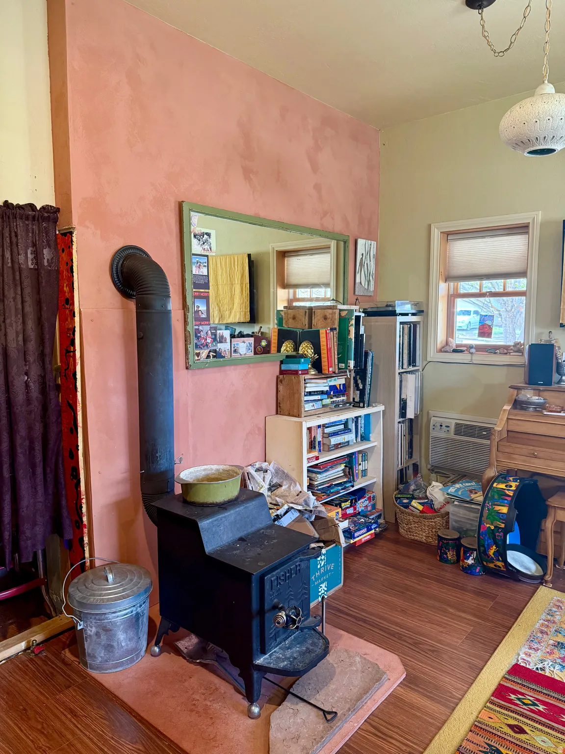 Bedroom featuring a wood stove and dark wood finished floors