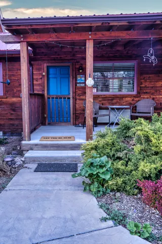 Doorway to property featuring covered porch
