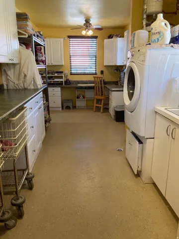 Laundry area featuring washer / clothes dryer, cabinet space, and a ceiling fan