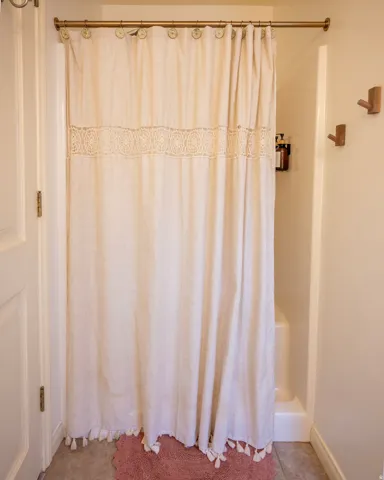 Full bathroom with baseboards and shower / bath combination with curtain