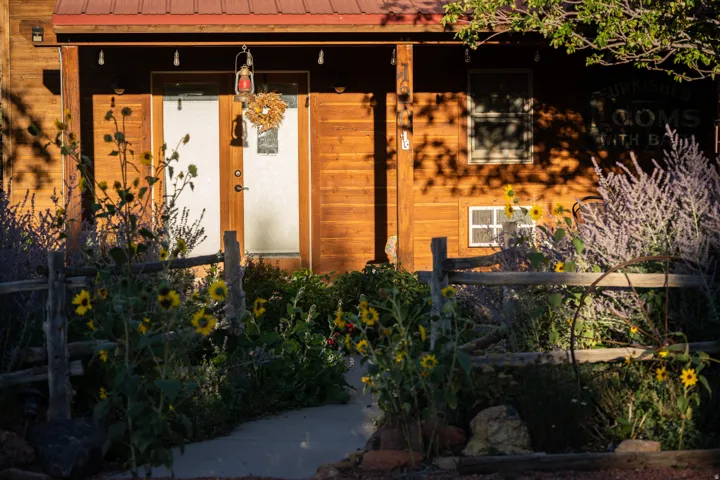 View of exterior entry with a porch and a metal roof