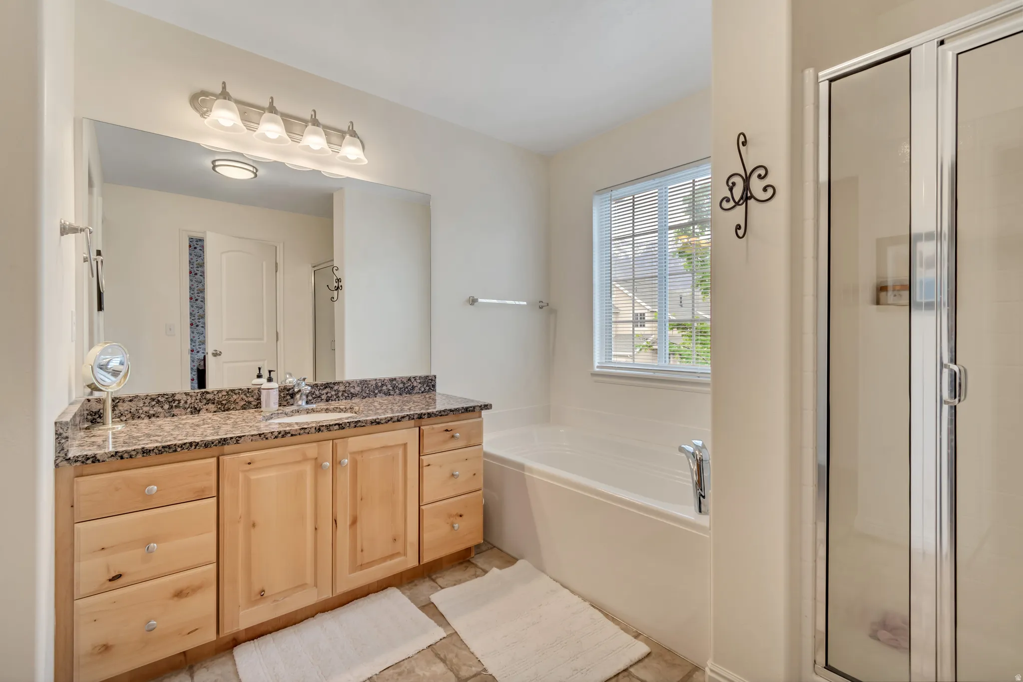 Bathroom featuring vanity, a bath, and a shower stall
