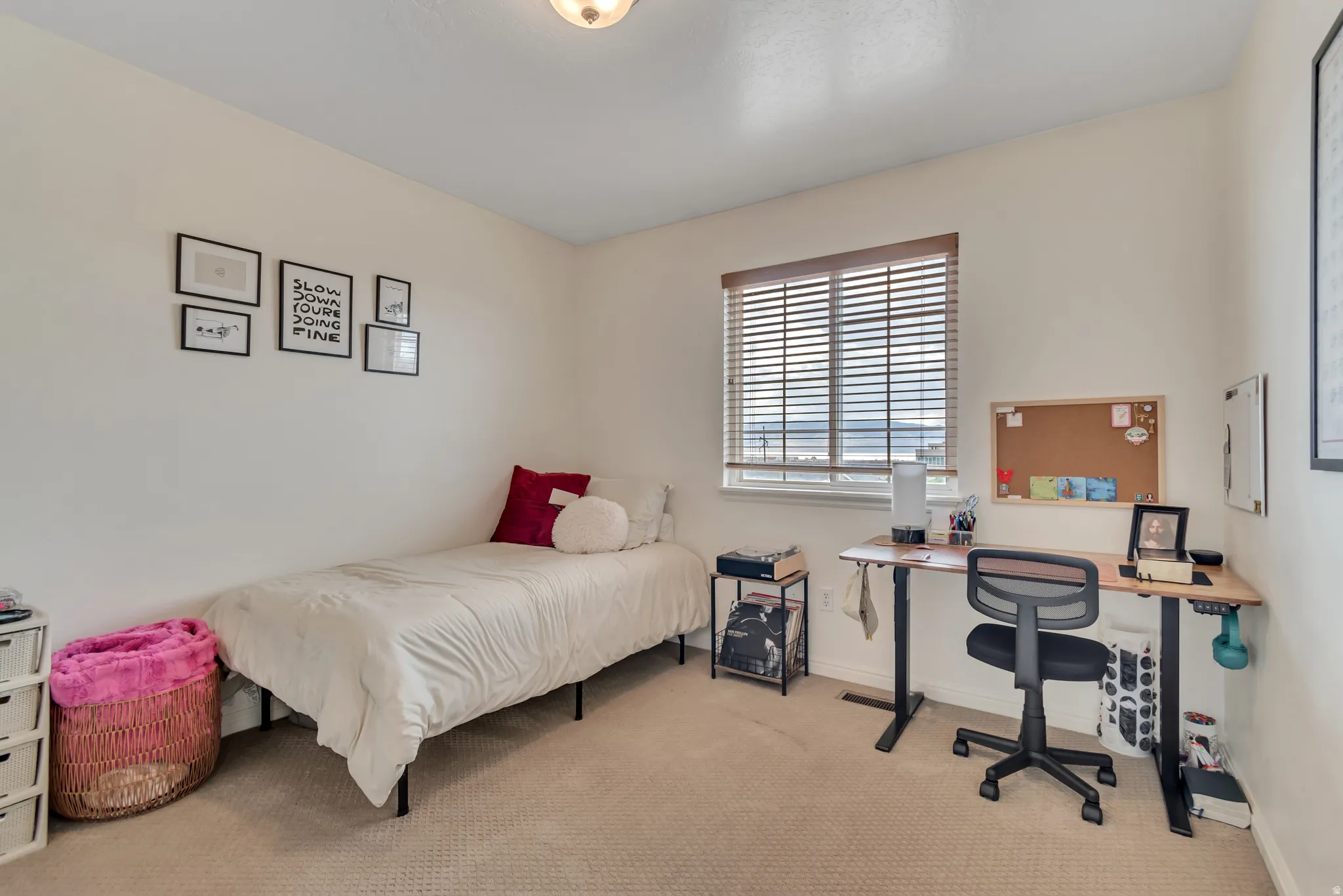 Bedroom featuring light colored carpet and an office area
