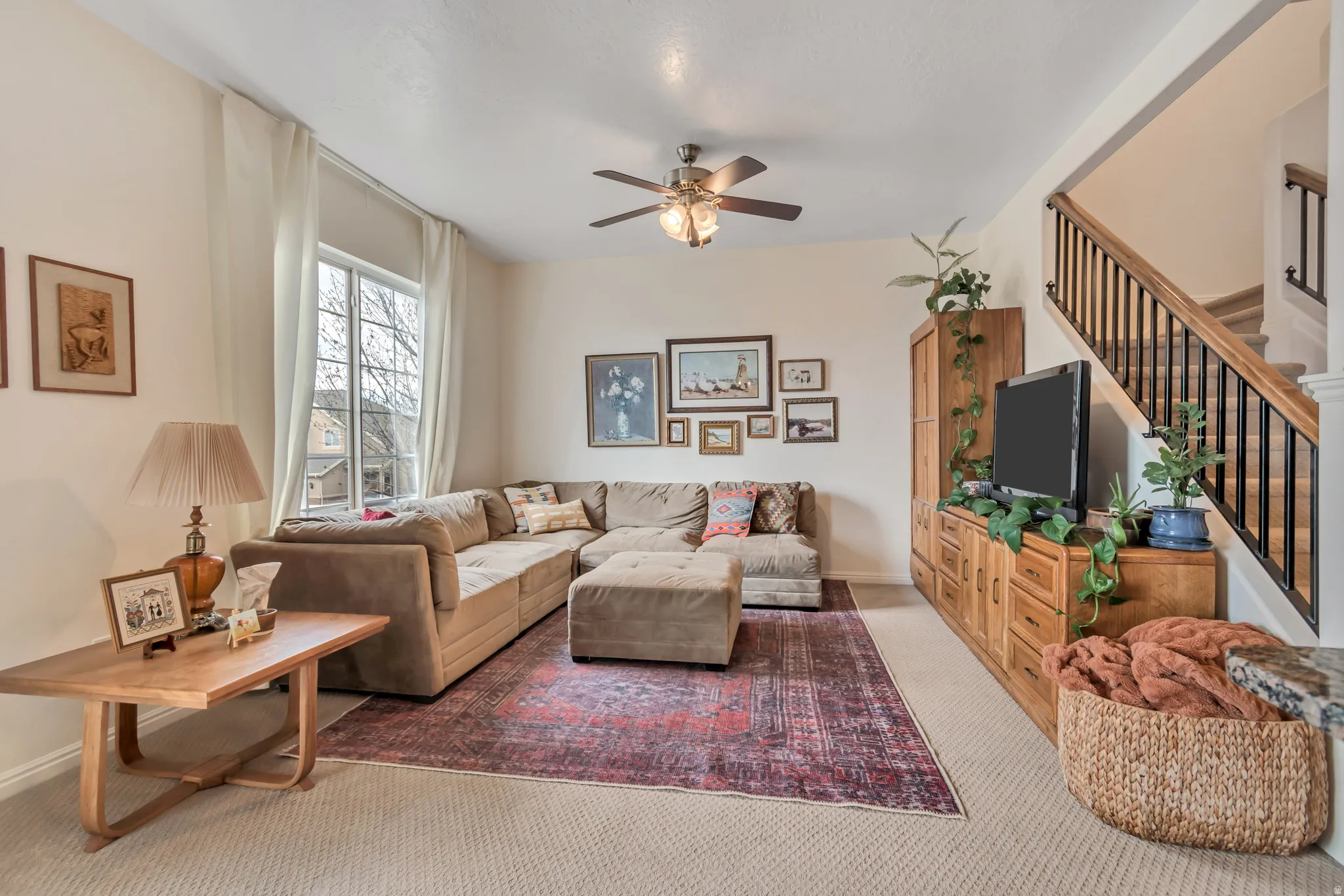 Living room featuring light colored carpet and a ceiling fan