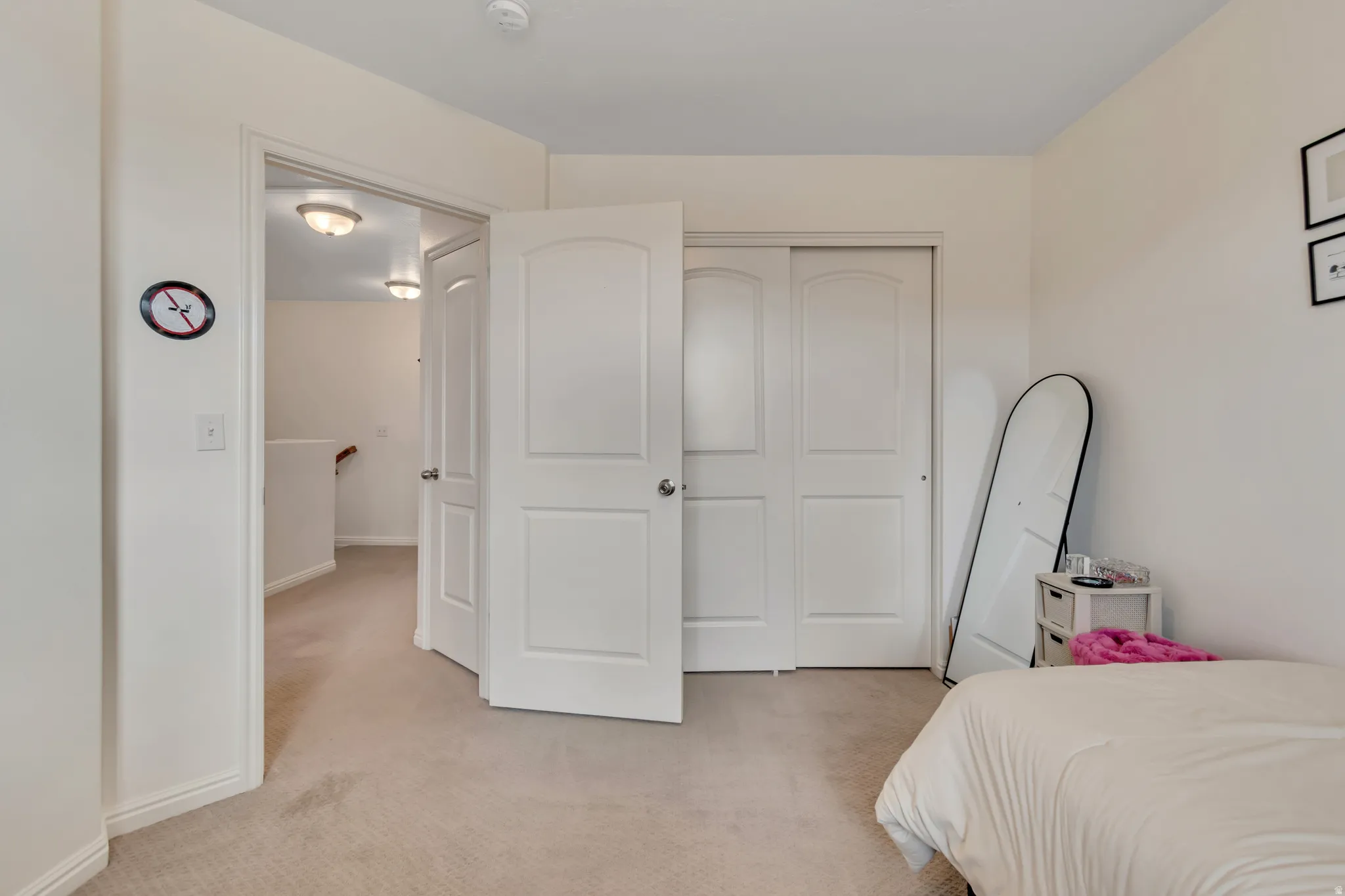 Bedroom featuring light colored carpet and a closet