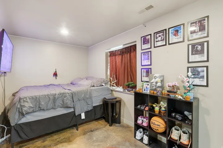 Bedroom with concrete floors and baseboards