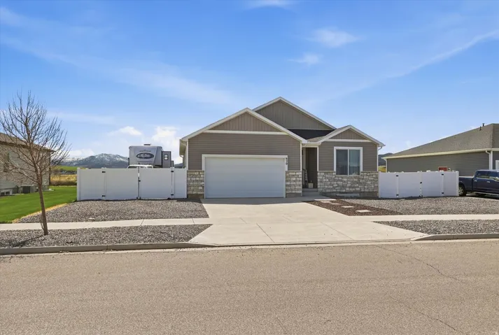Craftsman house featuring a gate, driveway, a garage, and stone siding