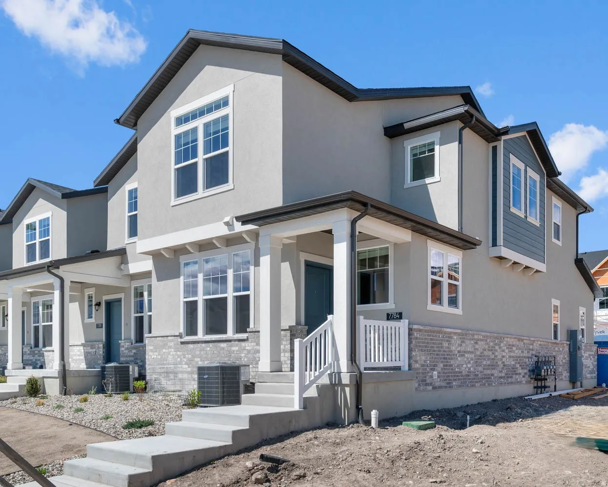 View of front of property featuring a porch, brick siding, stucco siding, and stone siding