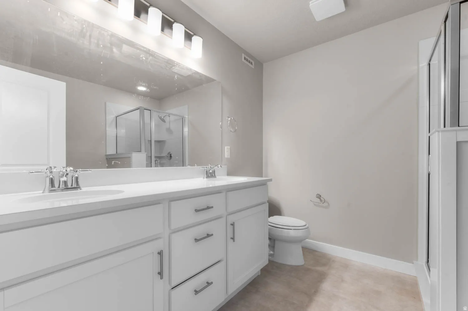 Full bathroom with double vanity and a stall shower