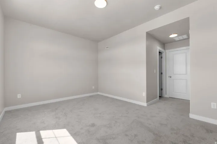 Spare room with light colored carpet and baseboards