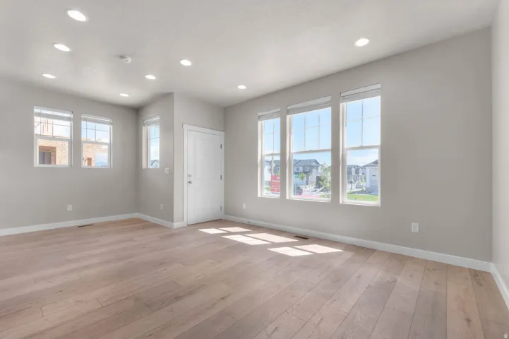 Empty room with light wood-type flooring and recessed lighting