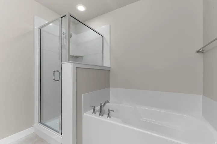 Bathroom with a stall shower, a garden tub, and recessed lighting
