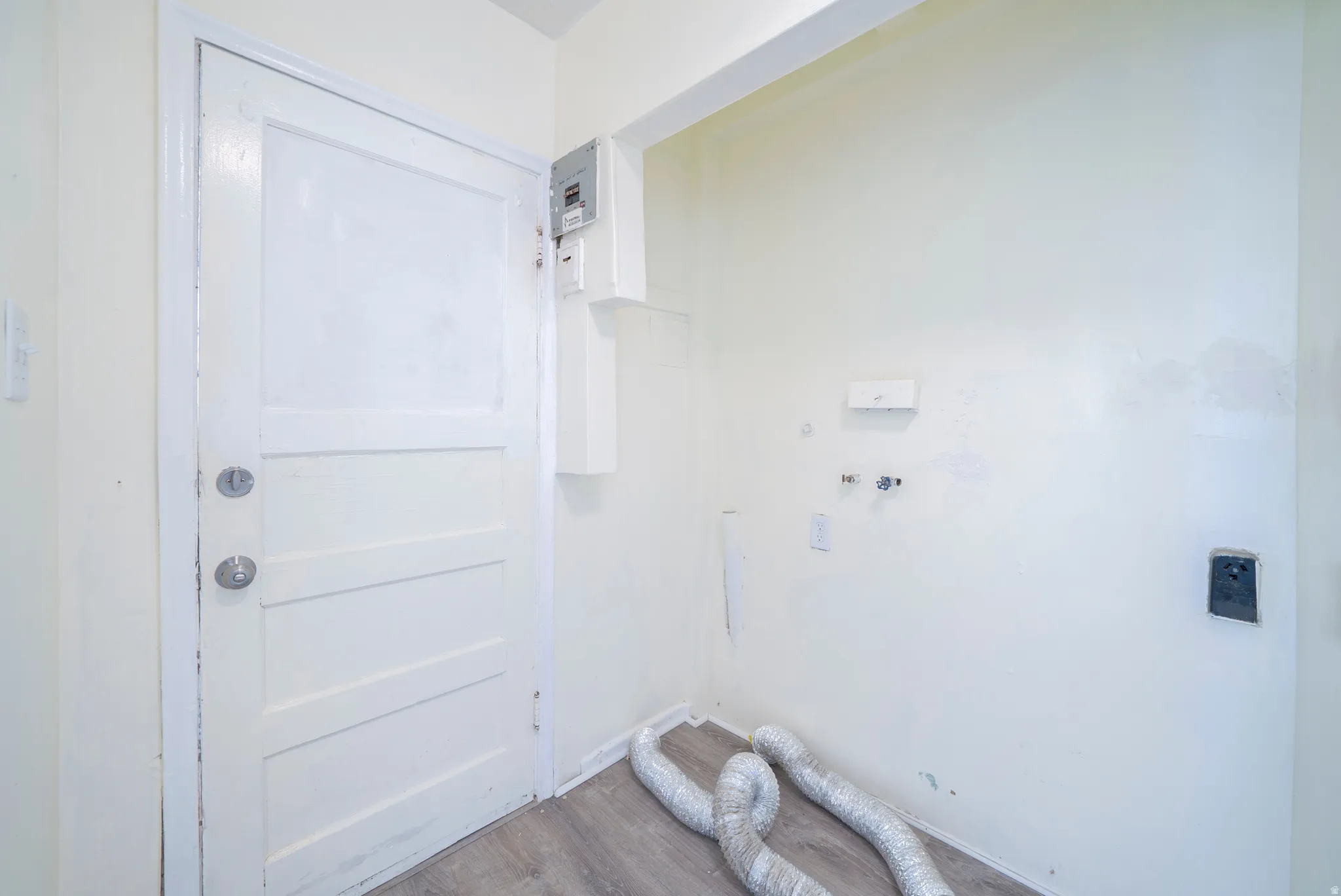 Laundry area featuring wood finished floors, hookup for a washing machine, and hookup for an electric dryer