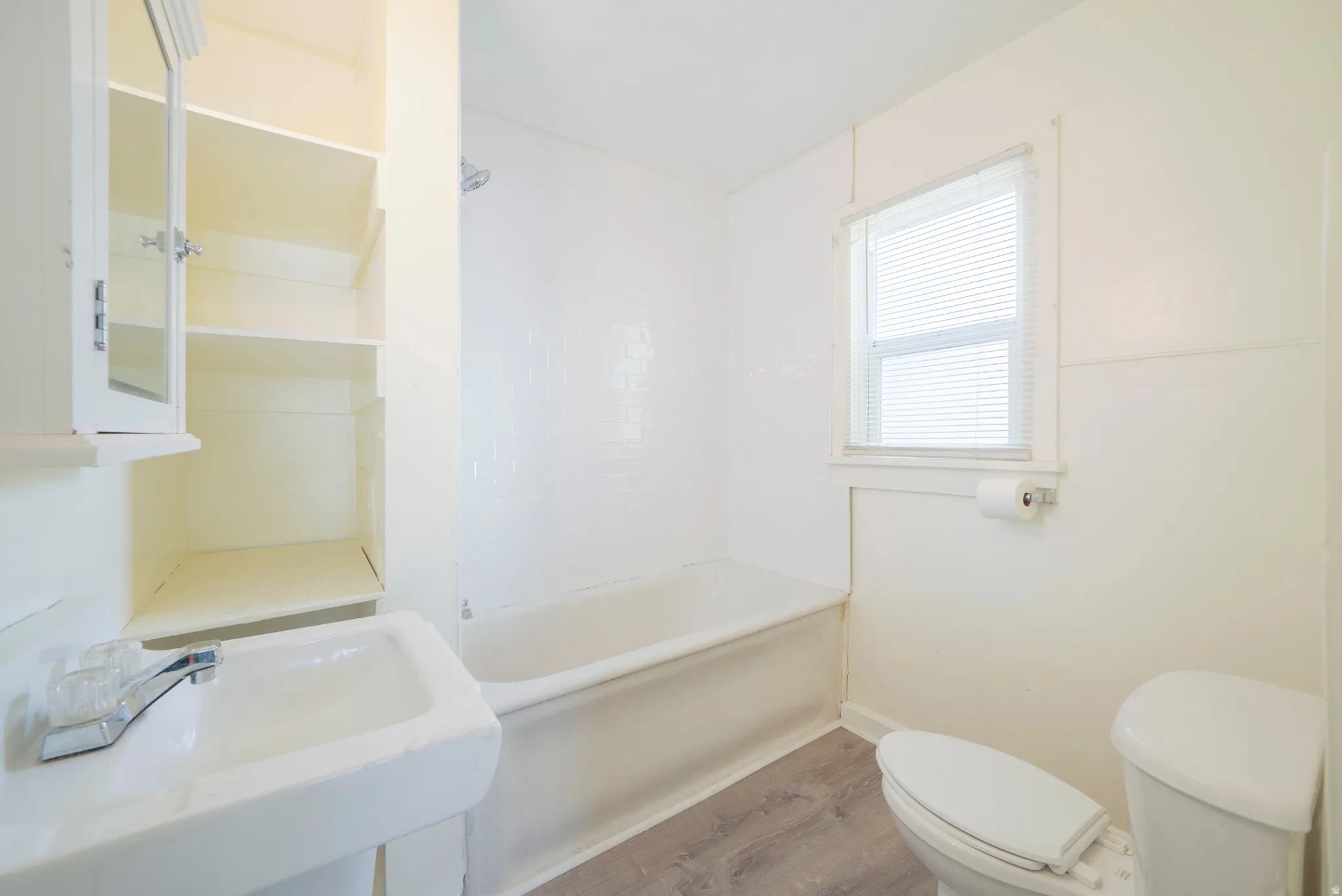 Bathroom with wood finished floors and shower / bathtub combination