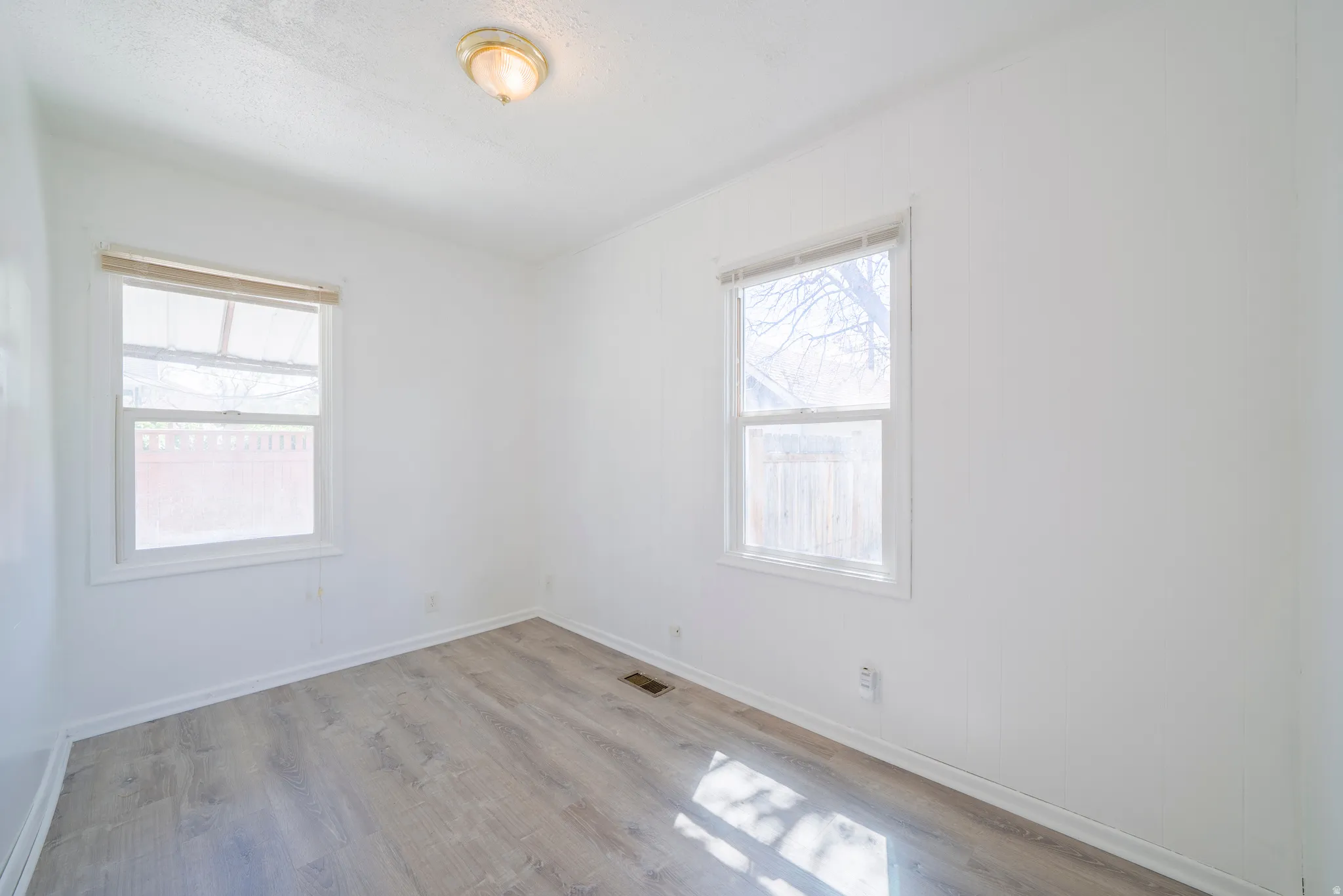 Spare room featuring light wood-type flooring and baseboards