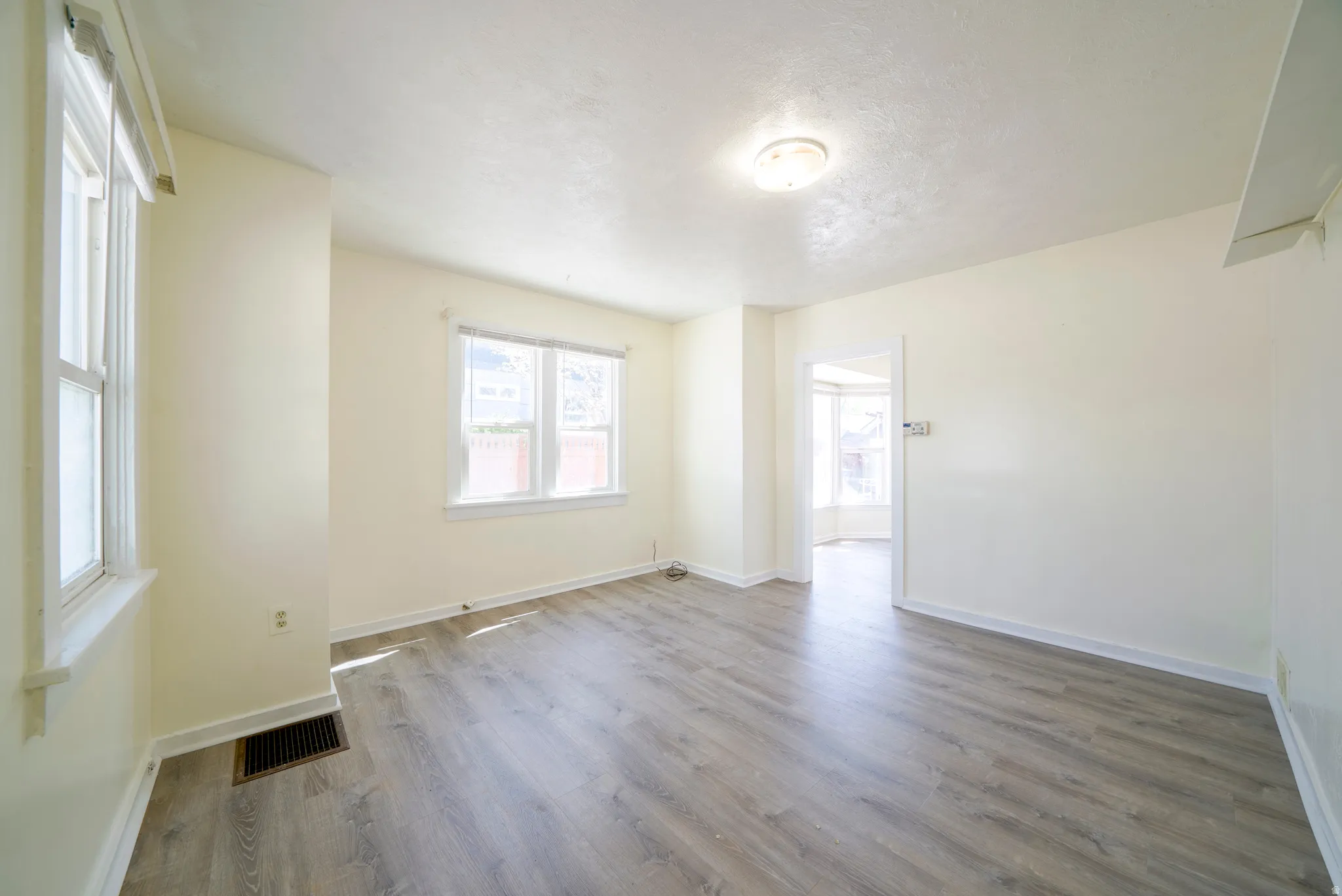 Unfurnished room with light wood-style floors and baseboards