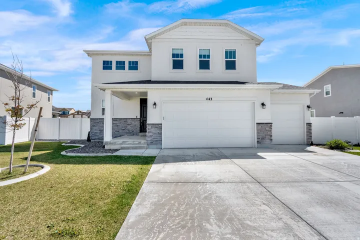View of front of house featuring stone siding, stucco siding, driveway, and an attached garage