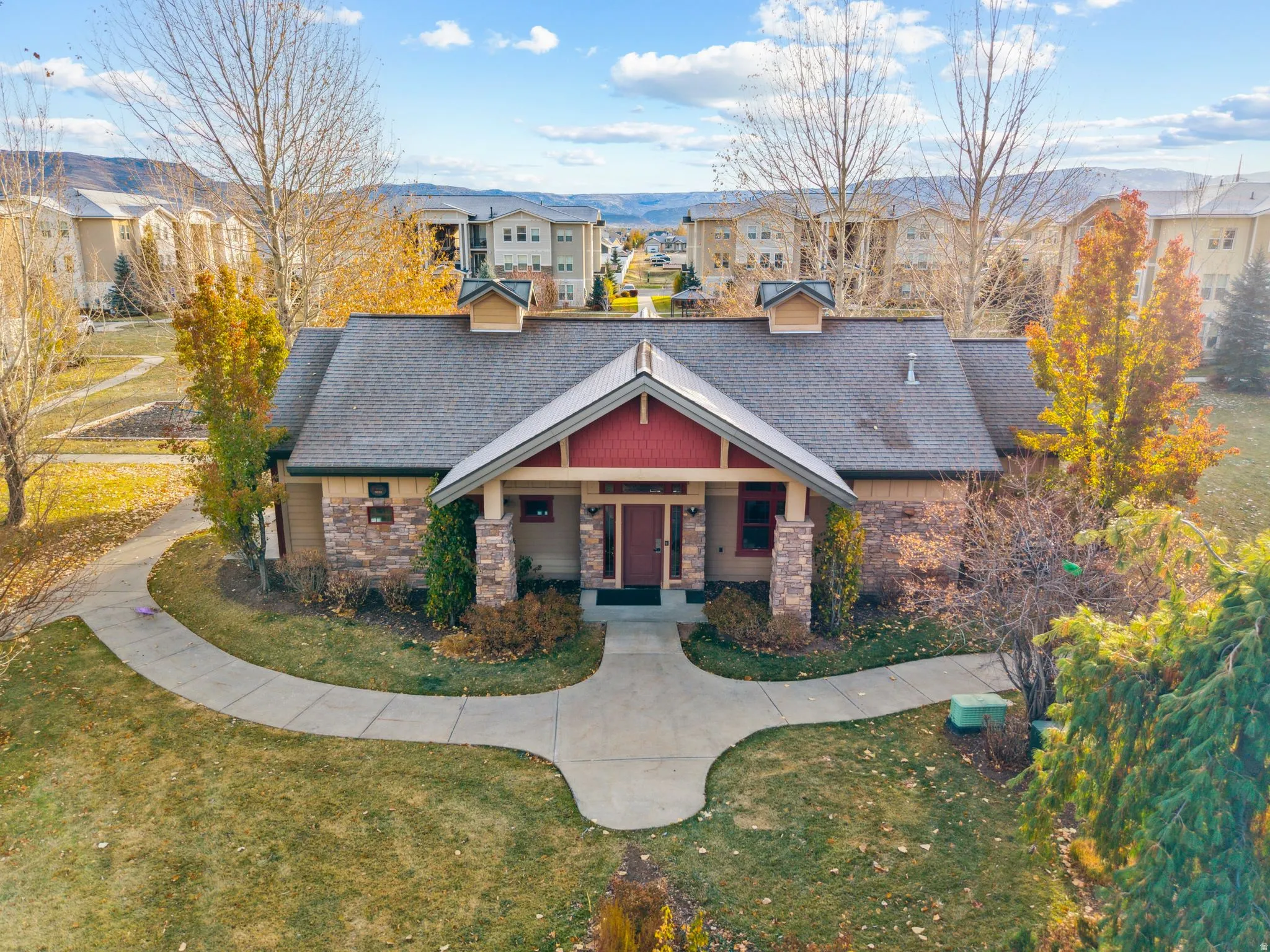 Craftsman-style house featuring covered porch, a front yard, roof with shingles, and stone siding