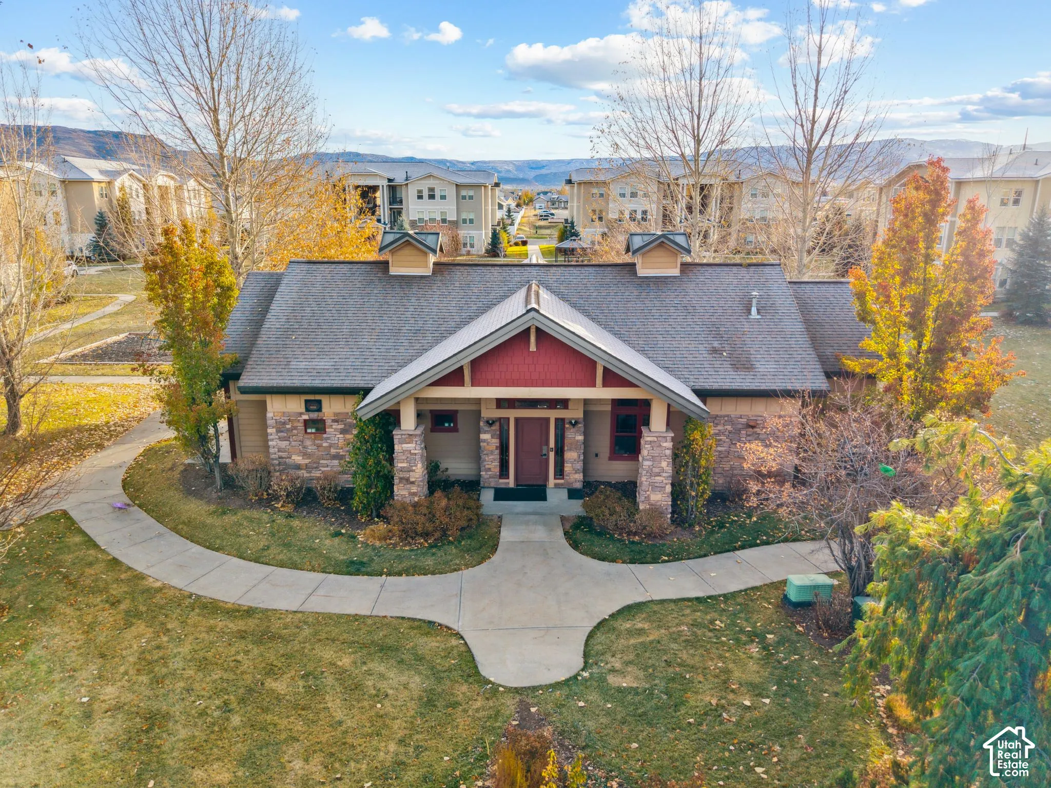 Craftsman-style house featuring covered porch, a front yard, roof with shingles, and stone siding