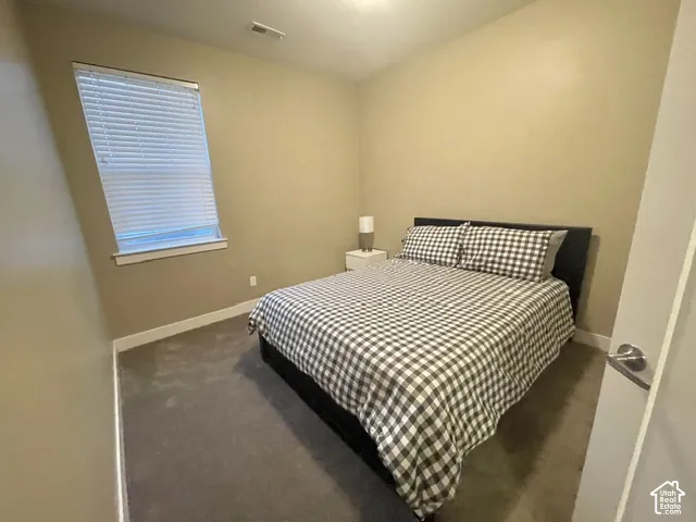 Neutral-toned walls complement the dark carpeting