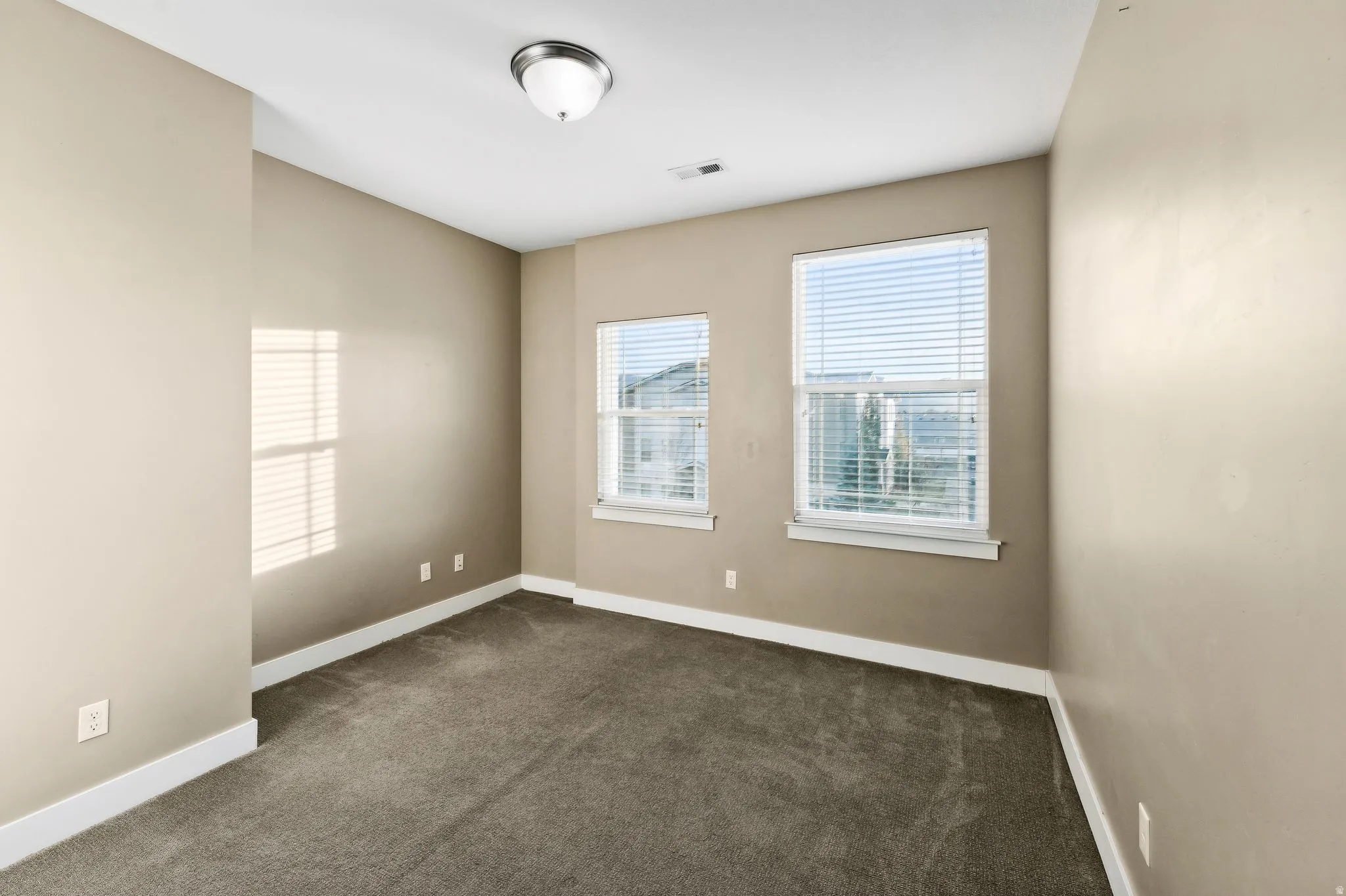 Unfurnished room featuring dark carpet and baseboards