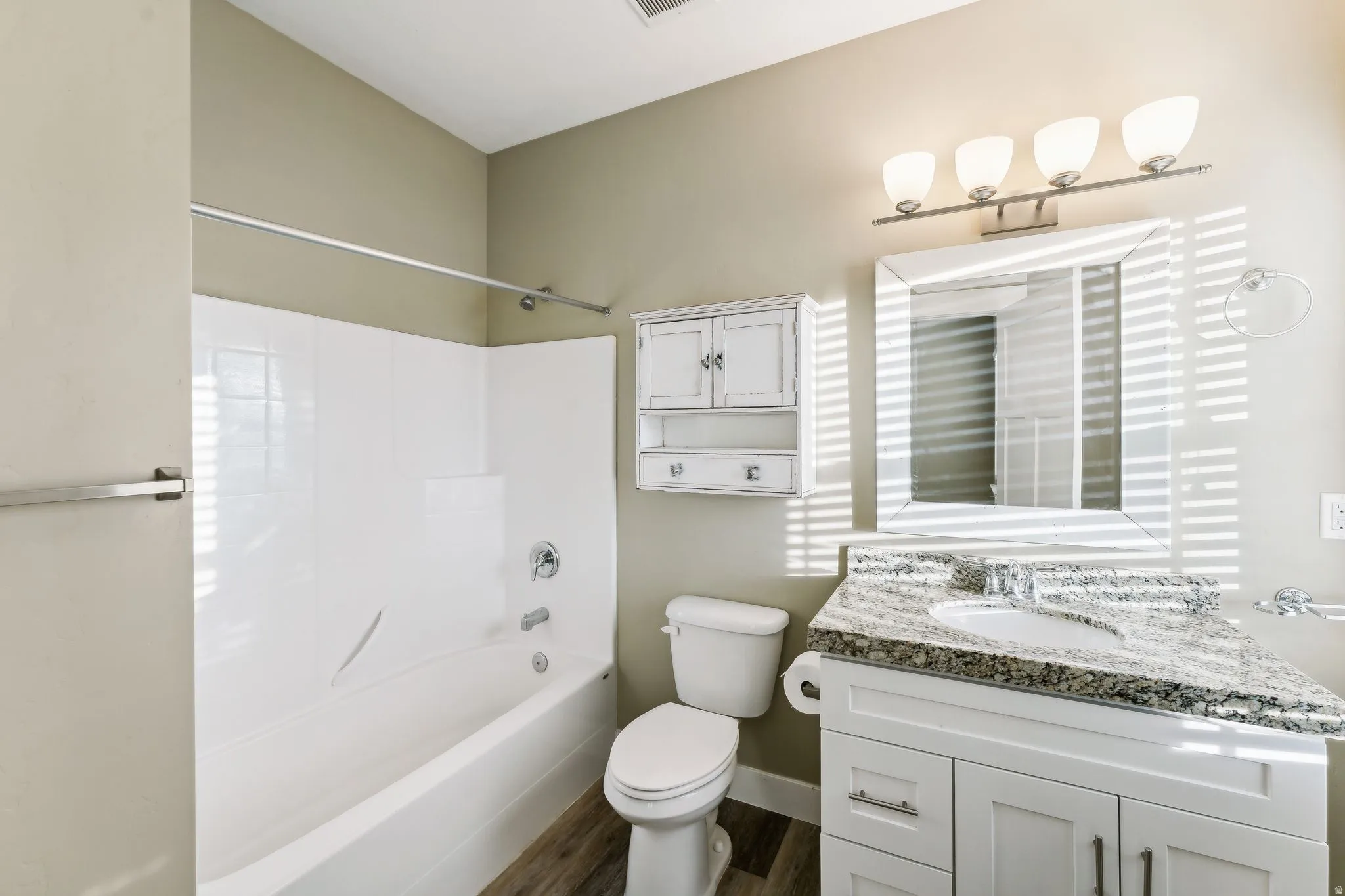 Full bath with vanity, shower / tub combination, and dark wood-type flooring