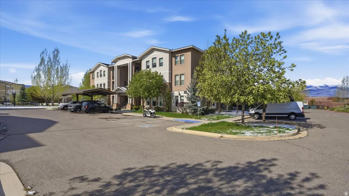 View of property featuring a mountain view and covered parking