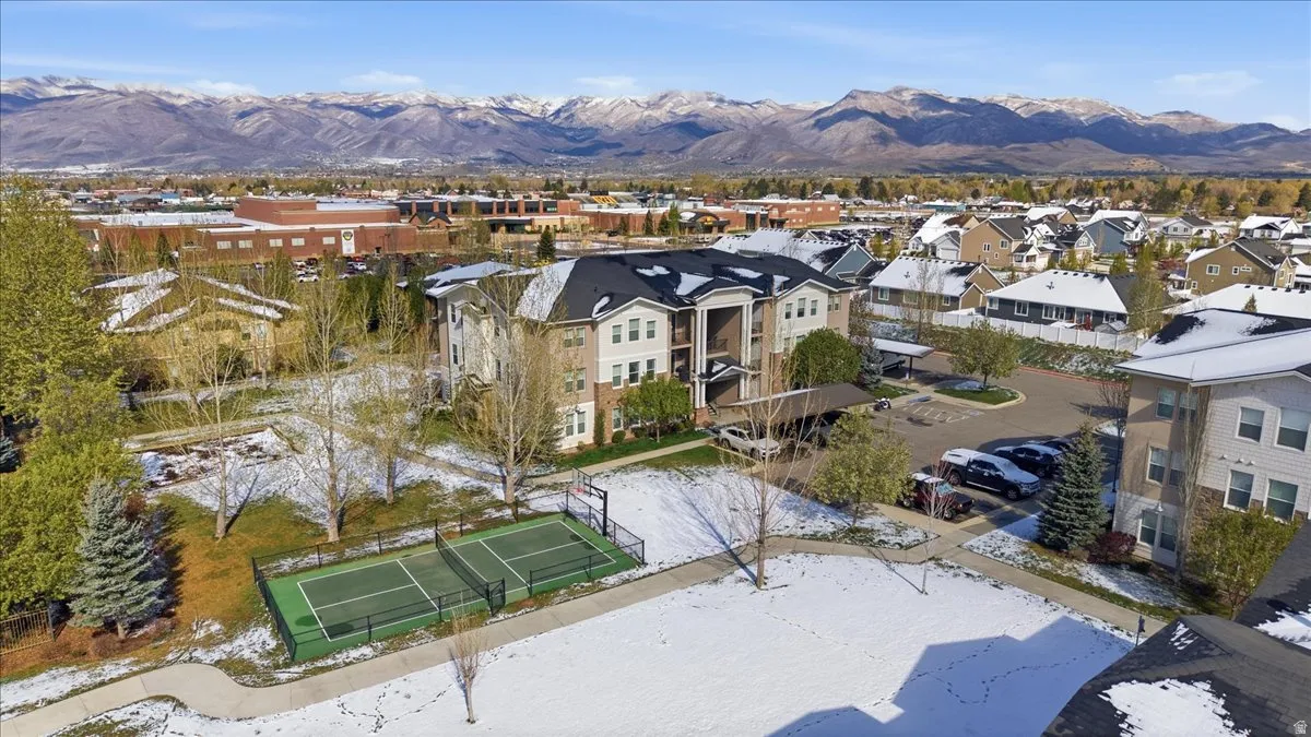 Snowy aerial view featuring a mountain view and a residential view