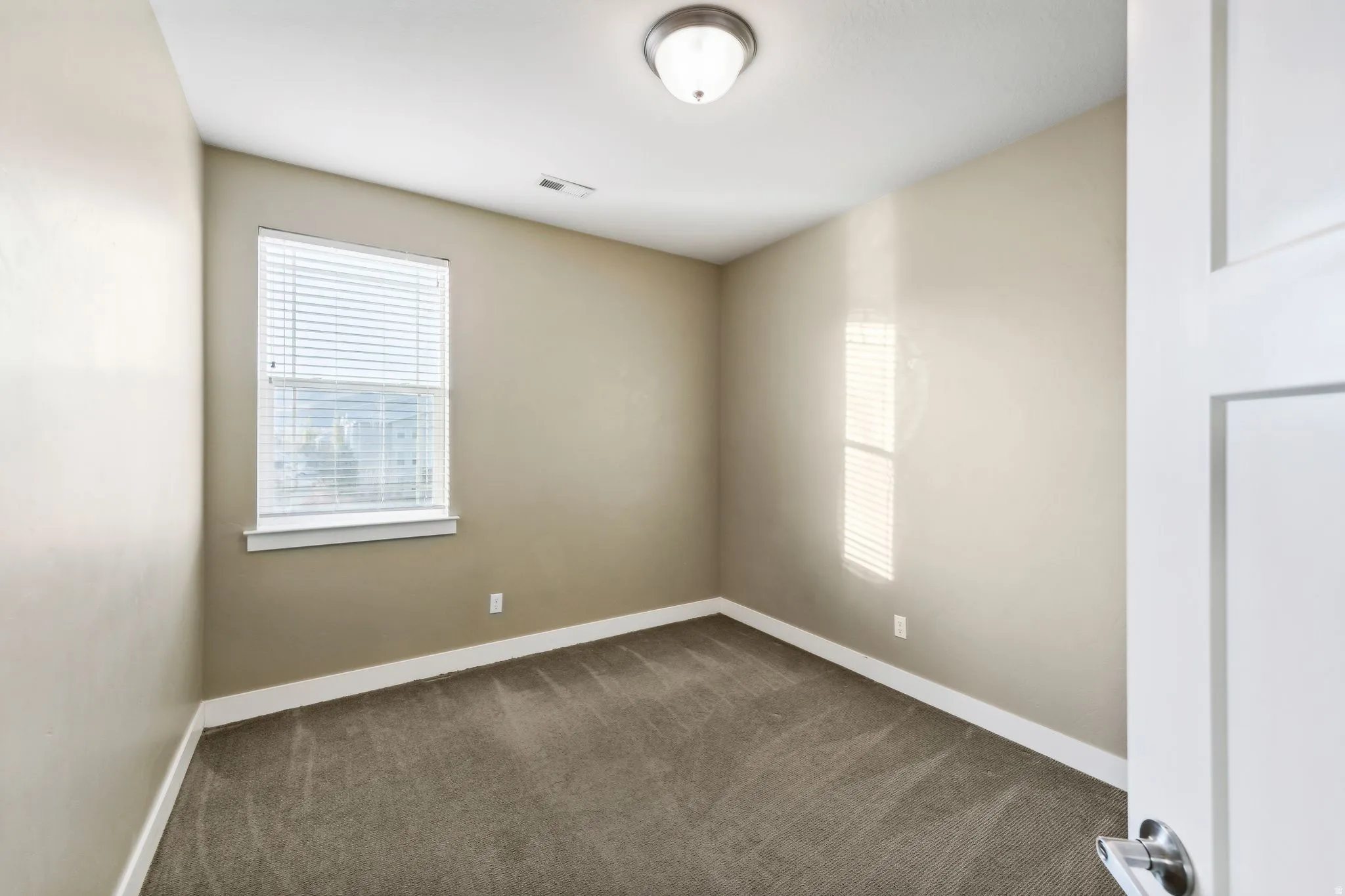 Unfurnished room with healthy amount of natural light and dark carpet