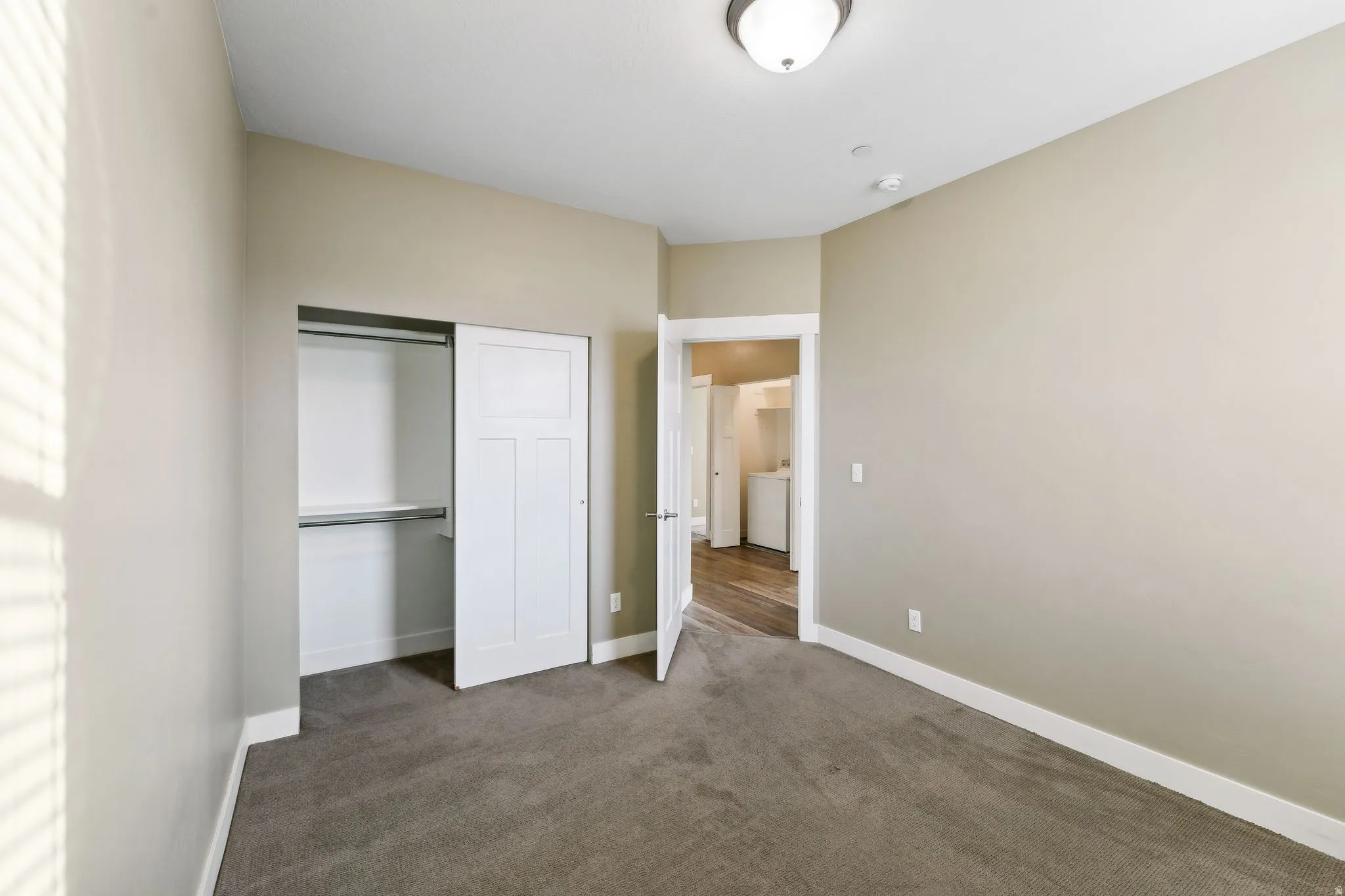 Unfurnished bedroom featuring dark colored carpet and a closet