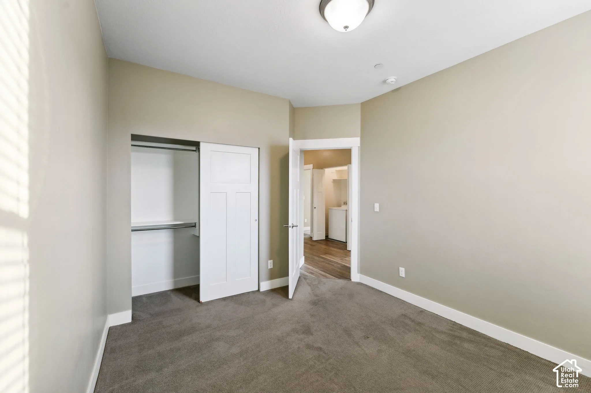 Unfurnished bedroom featuring dark colored carpet and a closet