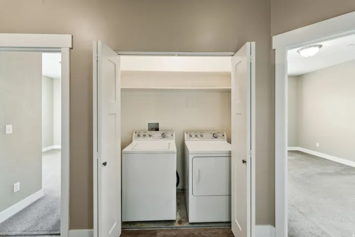 Laundry area featuring washer and clothes dryer and carpet floors