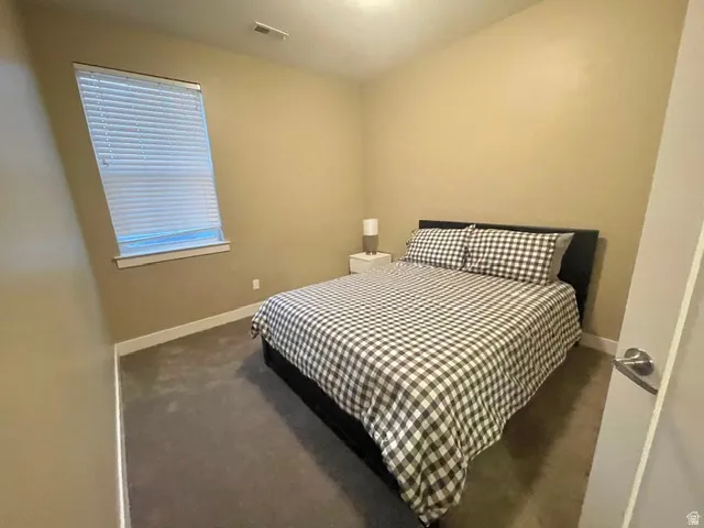 Neutral-toned walls complement the dark carpeting