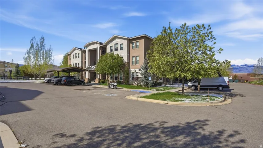 View of property featuring a mountain view and covered parking