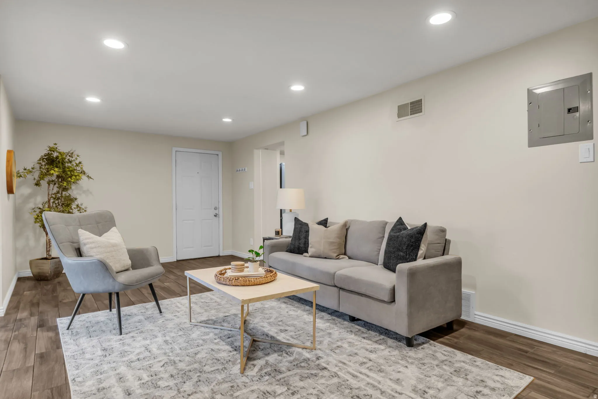 Living room featuring electric panel, recessed lighting, and wood finished floors