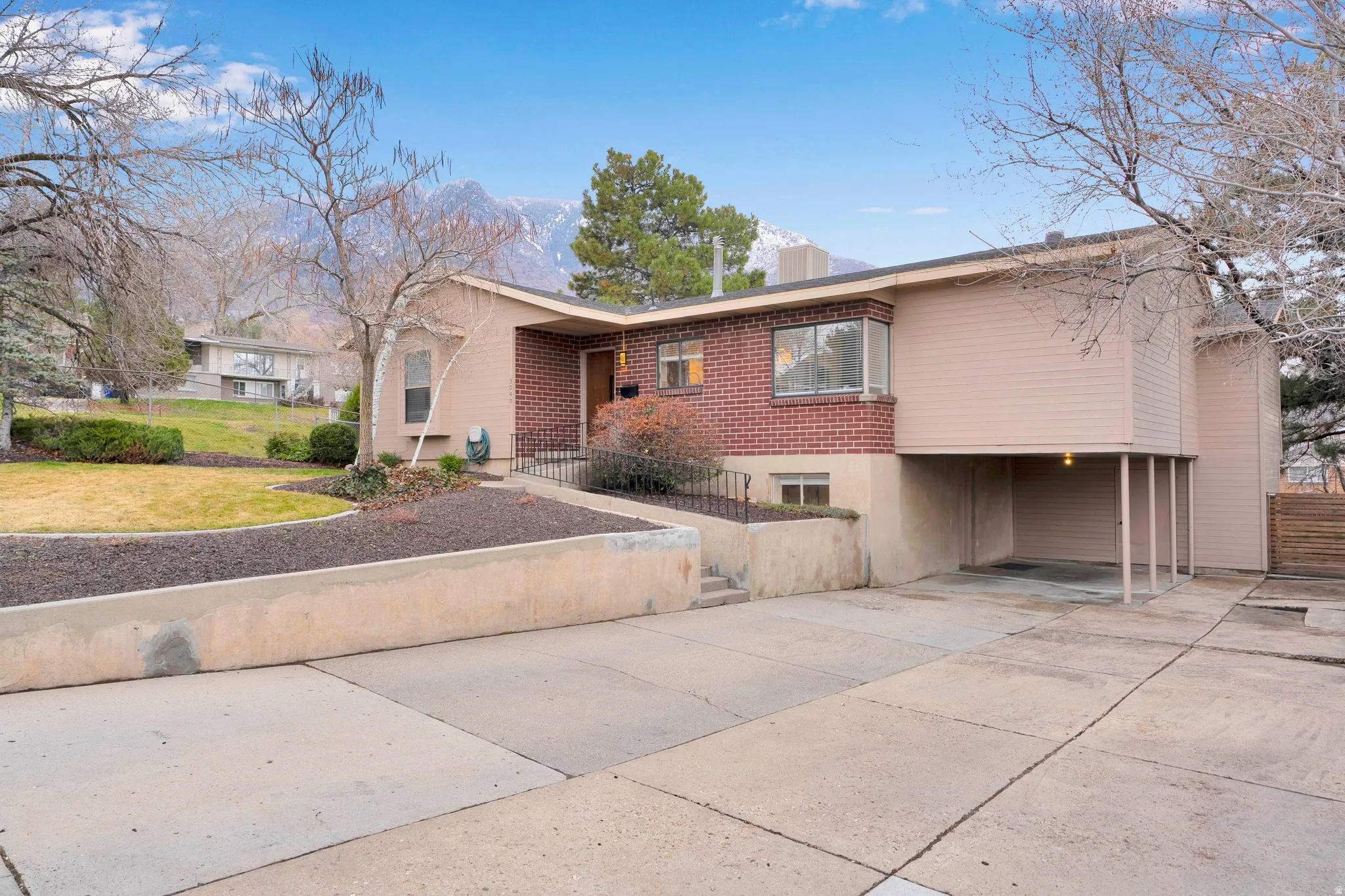 Ranch-style home featuring brick siding, a front yard, and concrete driveway