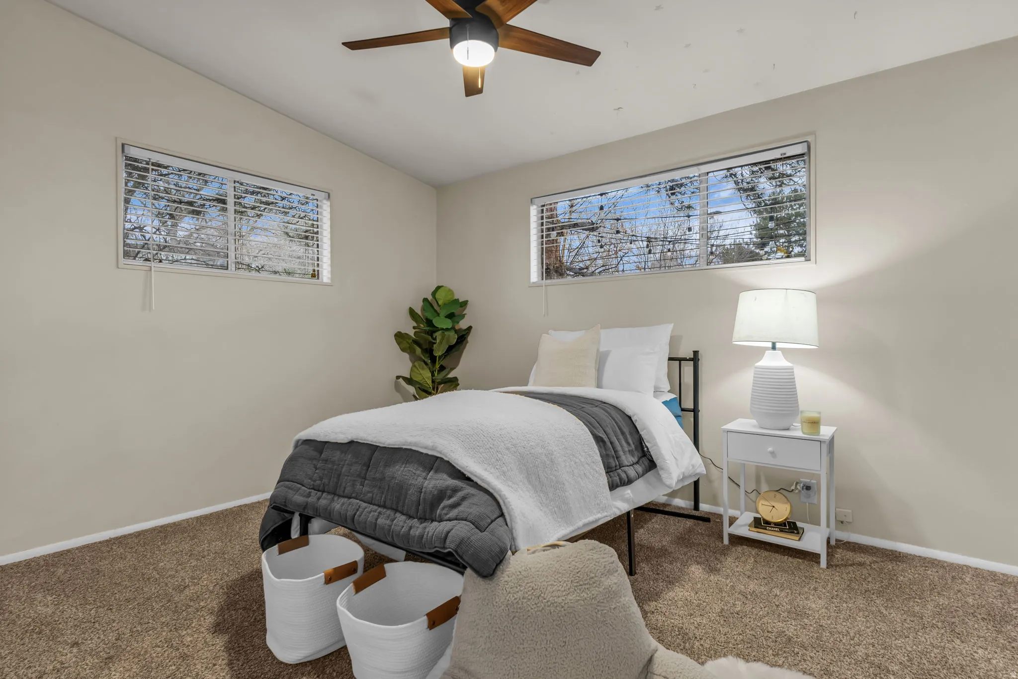 Bedroom with vaulted ceiling, carpet flooring, ceiling fan, and multiple windows