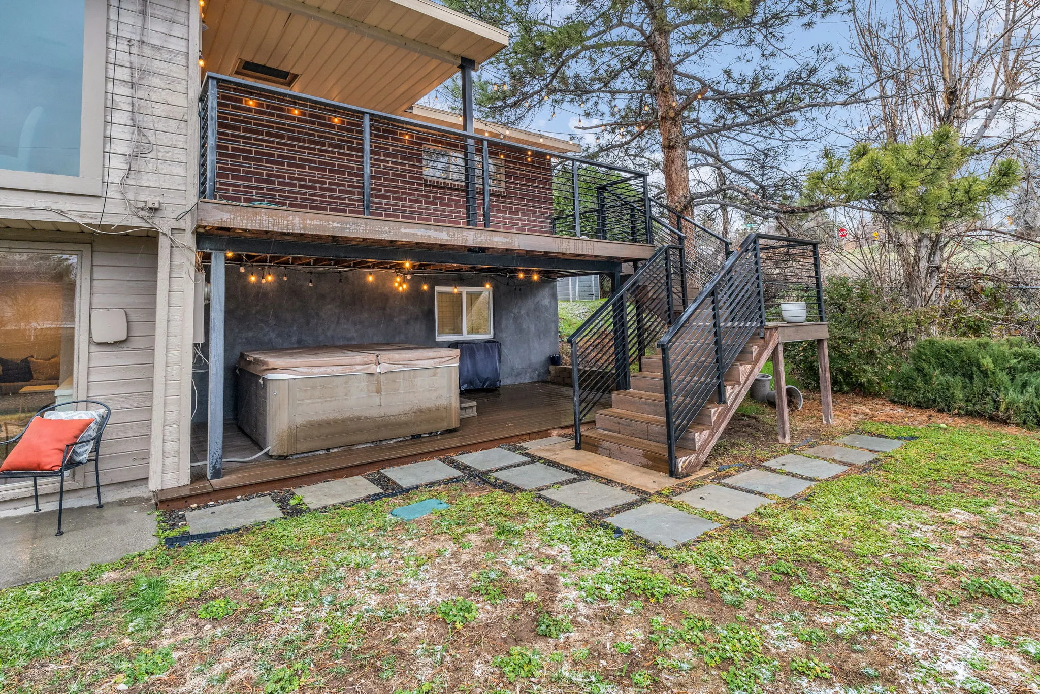 Back of property featuring a wooden deck and a hot tub