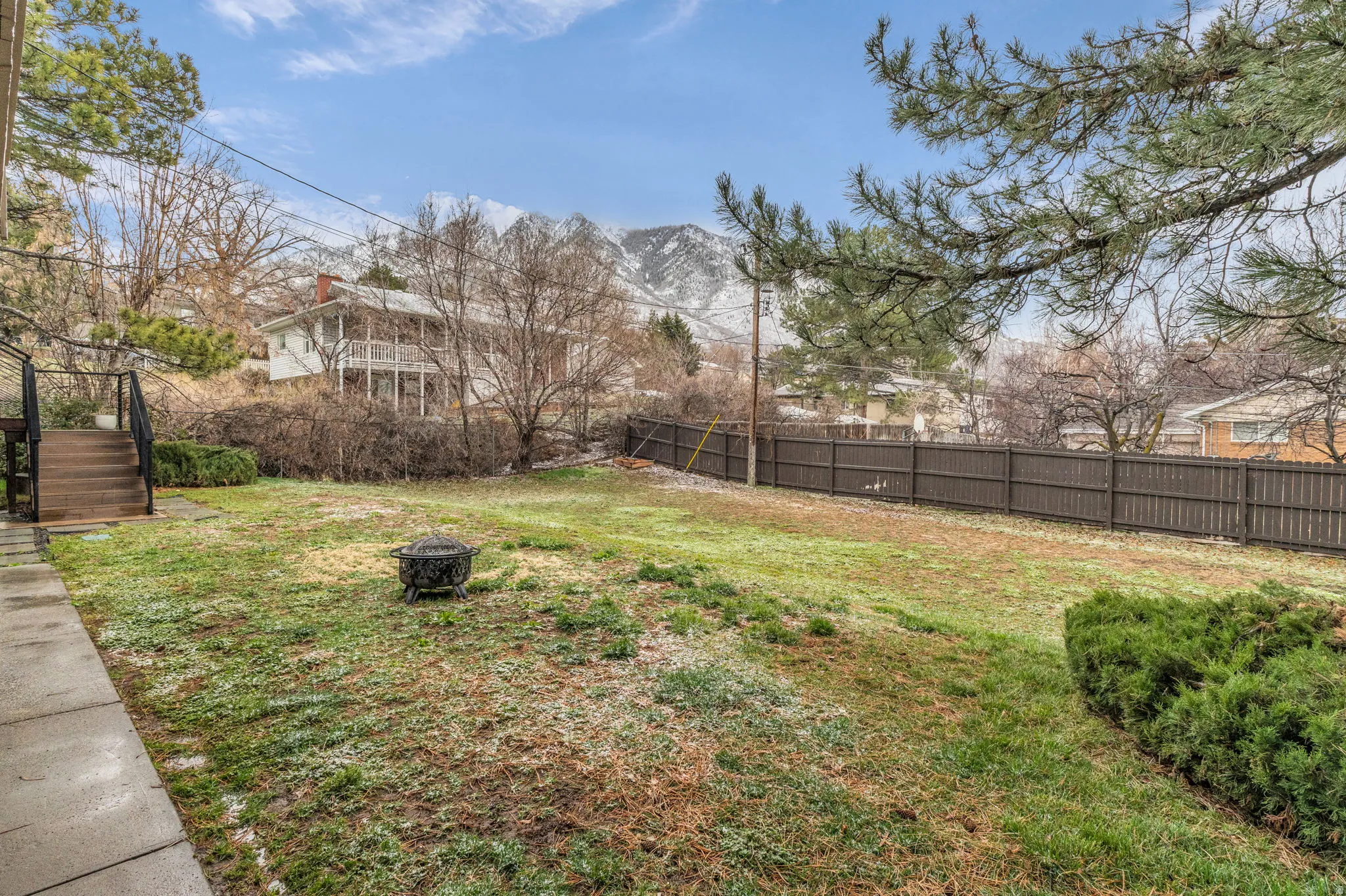 Fenced backyard with a fire pit and a mountain view